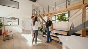 Poignée de main entre un couple et un conseiller ID Jardins dans un showroom paysager moderne et lumineux.